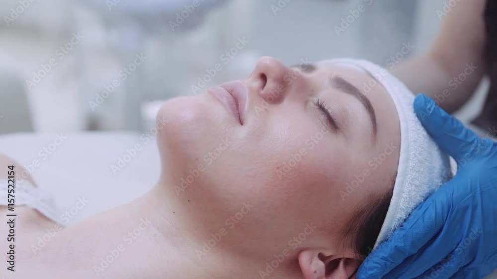 Close up view of a young attractive woman with closed eyes, lying on the cosmetologist’s table and having the steam cleaning procedure of the face. Taking care of the health, luxury spa. Close up view of a young attractive woman with closed eyes, lying on the cosmetologist’s table and having the steam cleaning procedure of the face. Taking care of the health, luxury spa.