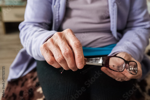 Wrinkled hands. The hands of the elderly man hold things in their hands. Old hands and glasses