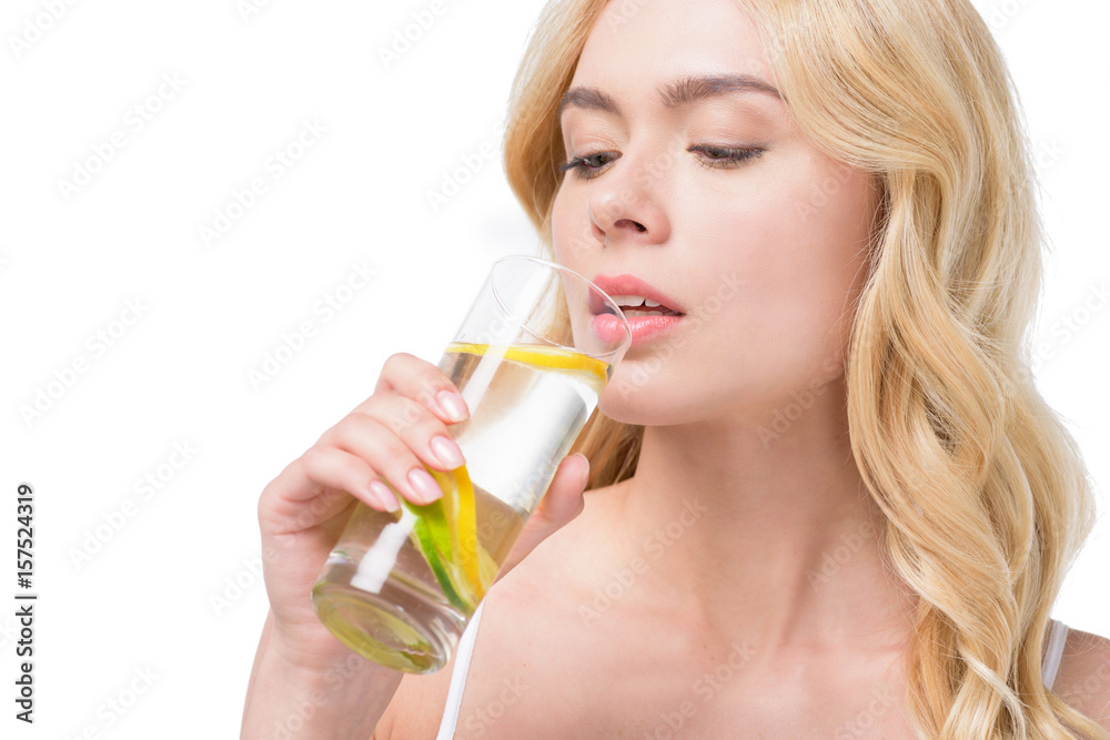 young caucasian woman drinking water with lemon from glass isolated on white young caucasian woman drinking water with lemon from glass isolated on white