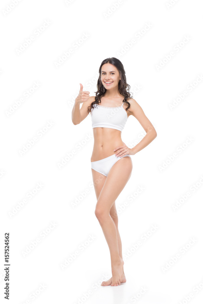 Beautiful young woman in white underwear showing thumb up and smiling at camera