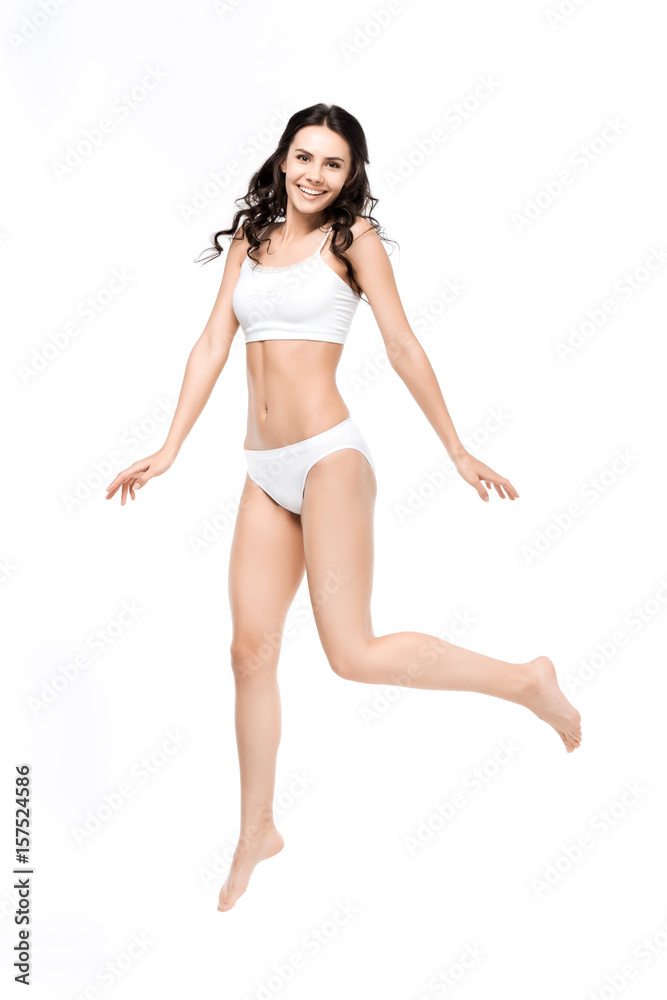 Smiling young woman with perfect body in white underwear jumping Smiling young woman with perfect body in white underwear jumping