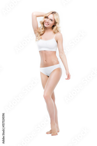 Young blonde woman posing in white underwear and smiling at camera