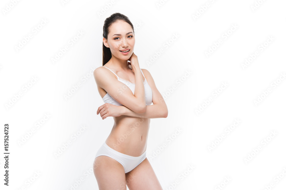 smiling asian girl looking at camera and posing in white underwear isolated on white smiling asian girl looking at camera and posing in white underwear isolated on white