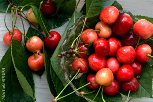 Cherries in a glass bowl with leaves around