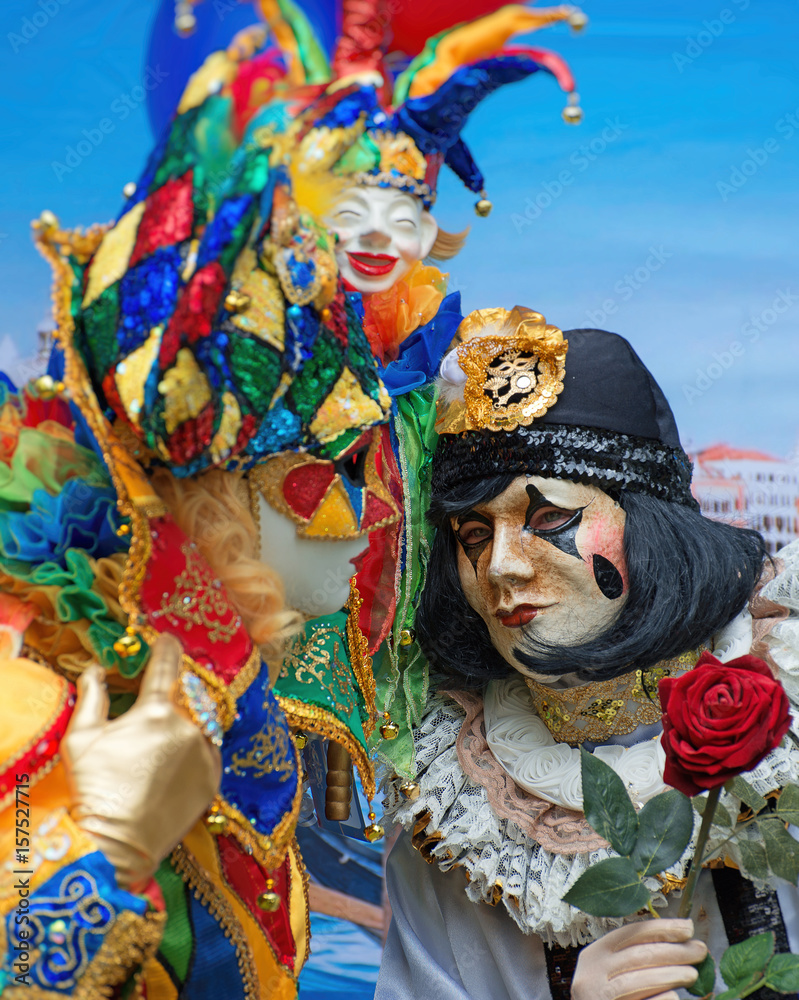 Unrecognizable people in venetian masks on street carnival.