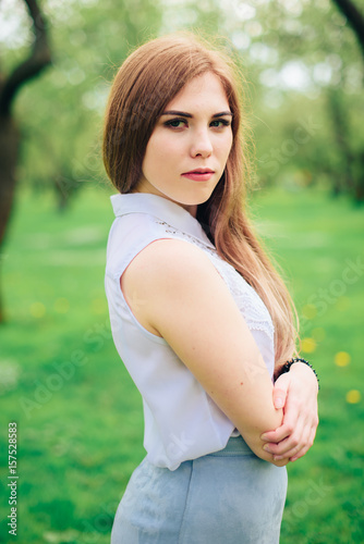 Beautiful woman in a summer park in sunny weather