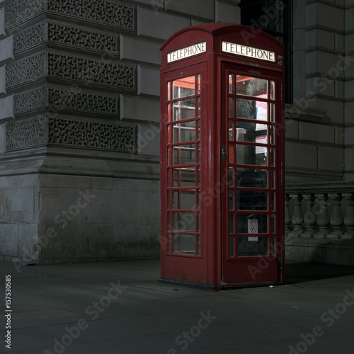 old red telephone booth at night in london