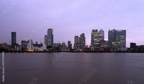 business part of london in uk canary wharf at dusk behind river thames