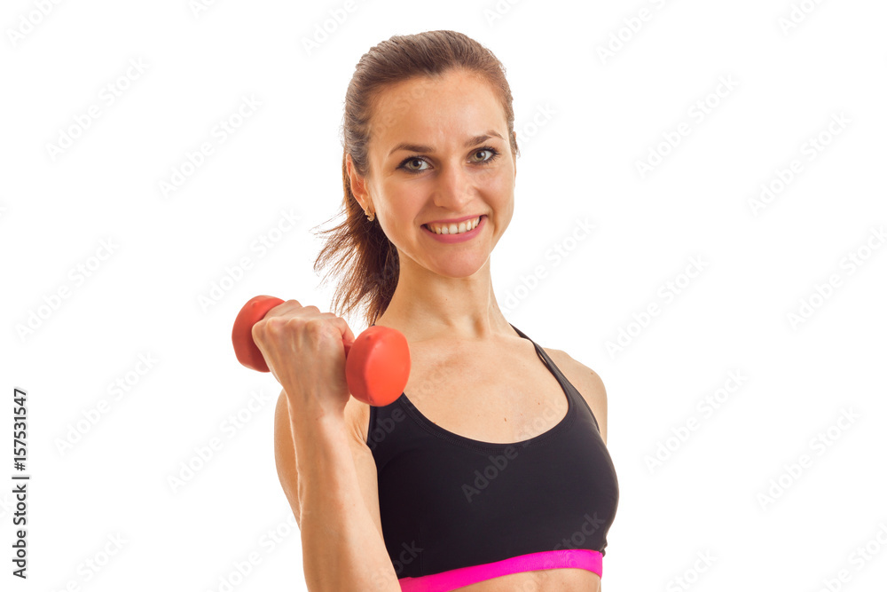 horizontal portrait of a beautiful girl who holds in her hand a dumbbell smiles and looks into a camera horizontal portrait of a beautiful girl who holds in her hand a dumbbell smiles and looks into a camera