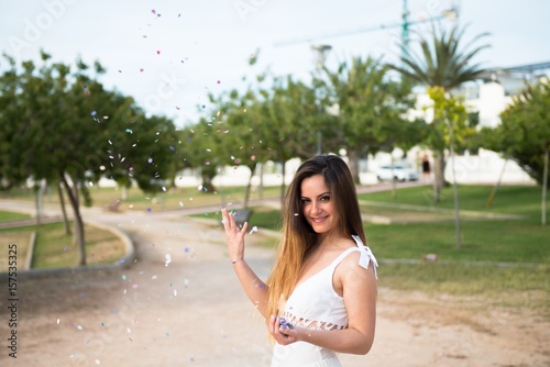 Beautiful young girl in a park with confetti