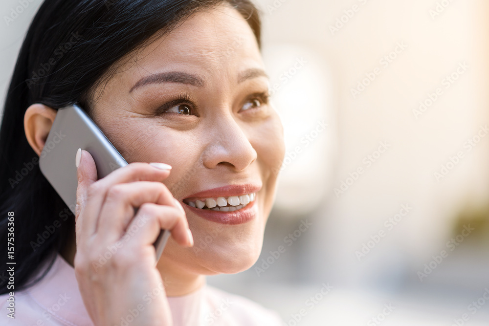 Cheerful woman speaking by mobile