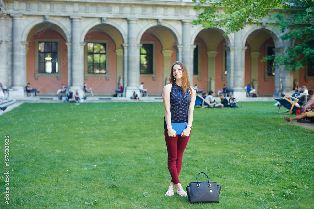 Fototapeta premium A young woman in front of university building