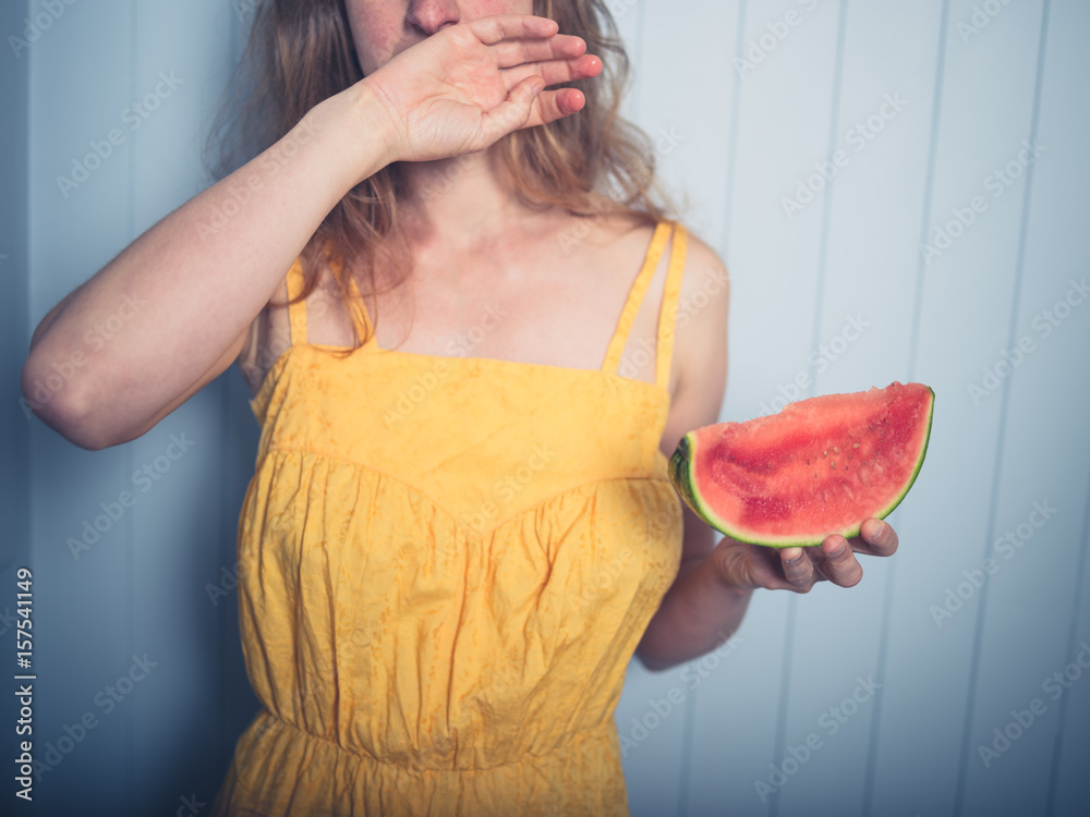Foto de Woman wiping face after eating water melon do Stock Adobe Stock