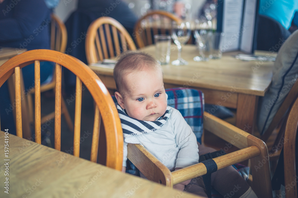 Cute little baby sitting at table in restaurant Cute little baby sitting at table in restaurant