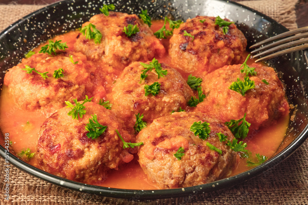 Closeup photo of meatballs in tomato sauce in skillet Closeup photo of meatballs in tomato sauce in skillet