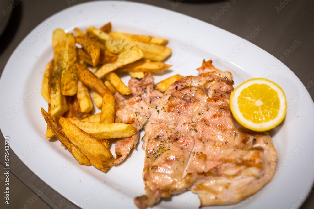 Grilled chicken fillet with french fries on the plate Grilled chicken fillet with french fries on the plate