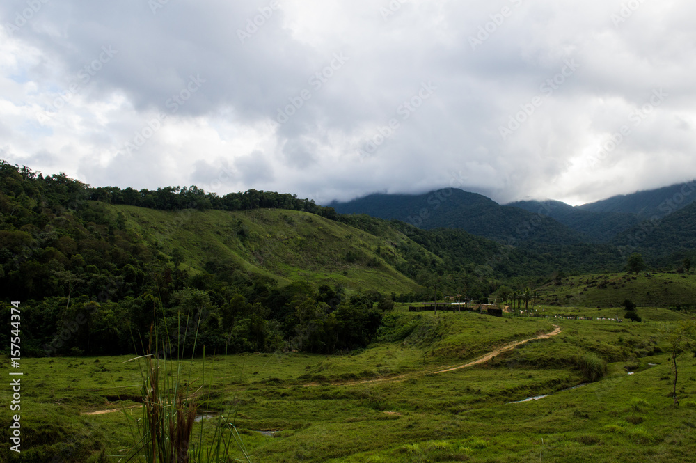 beautiful scenery of farm with clouds on the montains beautiful scenery of farm with clouds on the montains