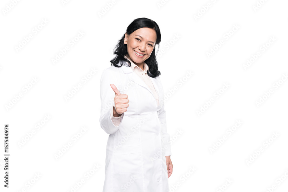 Cheerful brunette woman in white coat showing thumb up and looking at camera Cheerful brunette woman in white coat showing thumb up and looking at camera
