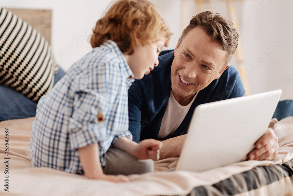 Positive delighted father looking at his child Positive delighted father looking at his child