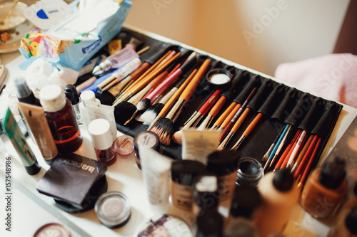 Make-up brushes in leather holder lie on dressing table