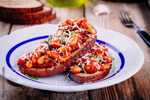 bruschetta with baked beans in tomato sauce with rosemary
