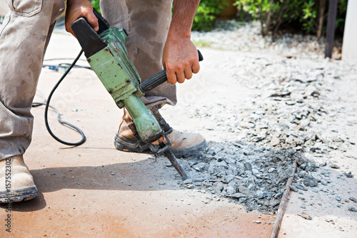 worker man mason drilling cement concrete floor with machine