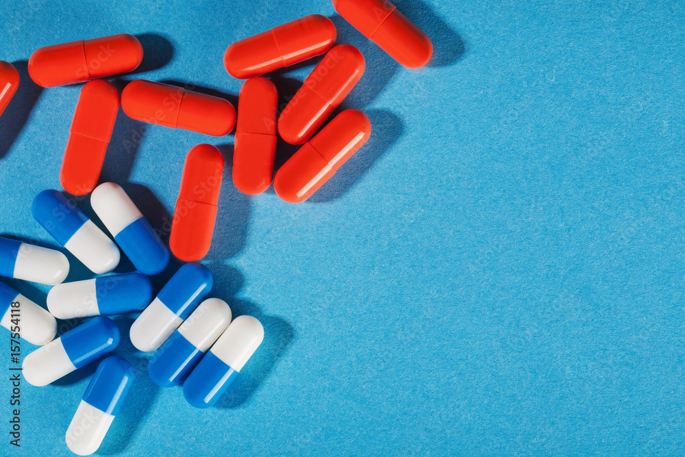Medical pills white-blue and red on a bright background Medical pills white-blue and red on a bright background
