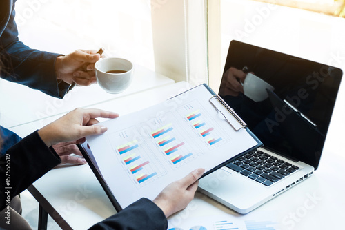 Business people discussing the charts and graphs showing the results of their successful teamwork, business concept