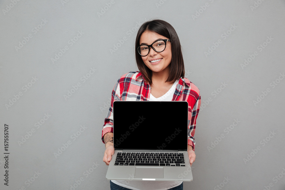 Happy young asian woman showing display of laptop computer. Happy young asian woman showing display of laptop computer.