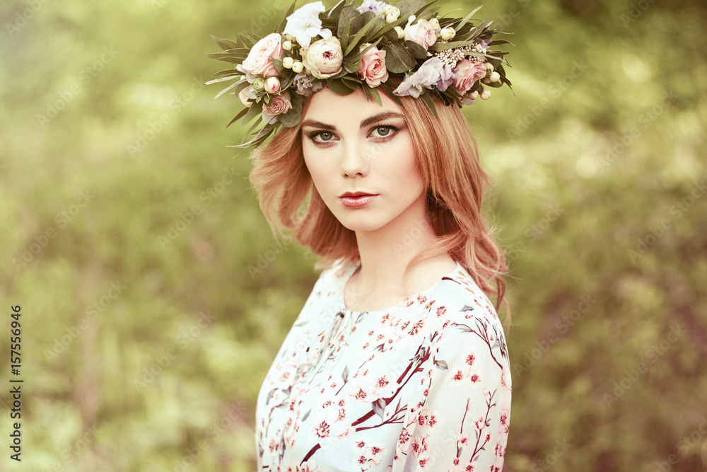 Beautiful blonde woman with flower wreath on her head. Beauty girl with flowers hairstyle. Girl in a summer forest. Fashion photo Beautiful blonde woman with flower wreath on her head. Beauty girl with flowers hairstyle. Girl in a summer forest. Fashion photo