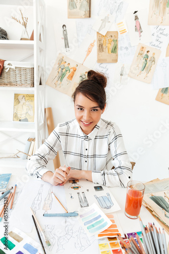 Portrait of a smiling female fashion designer creating sketches