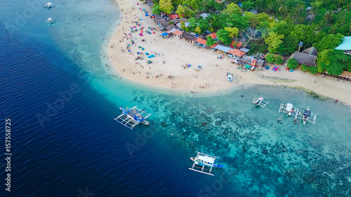 Aerial view of sandy beach with tourists swimming in beautiful clear sea water of the Sumilon island beach landing near Oslob, Cebu, Philippines. - Boost up color Processing. photo