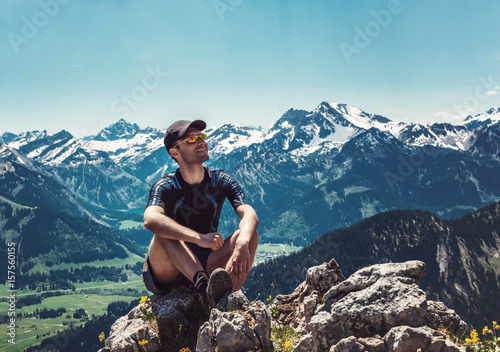 Man sitting and relaxing on mountain summit