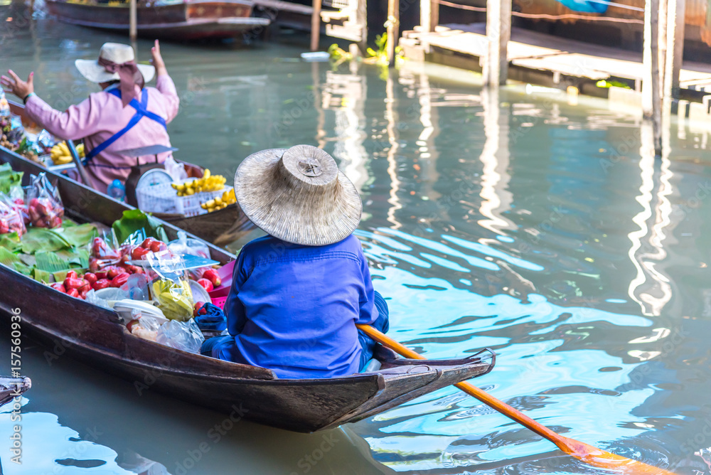 Naklejka premium Traders are rowing boats to sell fruit at the floating market.Traditional floating market , Thailand.