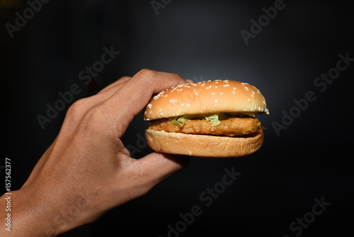 Hamburger in the hand on a background