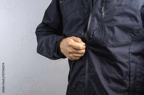 Man wearing black anti static or wet weather jacket or rain coat © bonnontawat