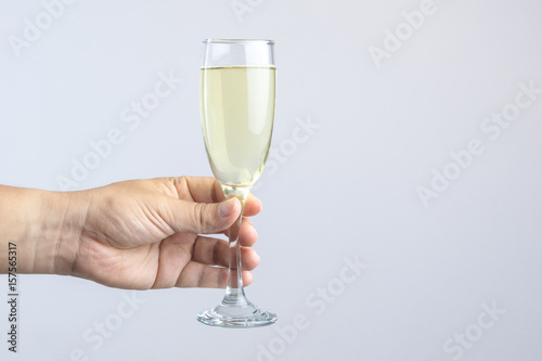 Hand holding glass of champagne for celebration on white backgroun