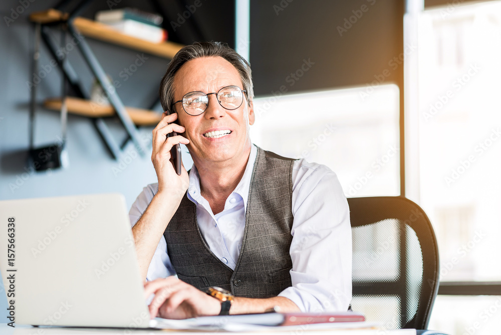 Cheerful confident senior businessman talking on mobile phone Cheerful confident senior businessman talking on mobile phone