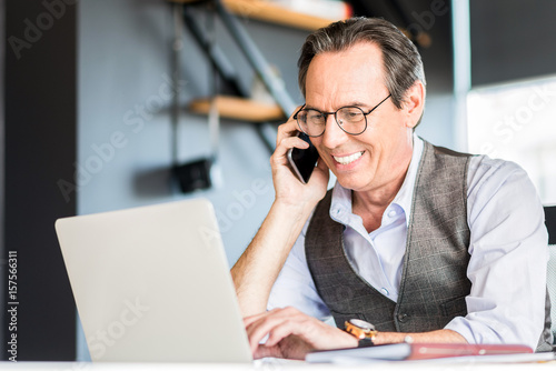 Adult joyful man is having communication on mobile