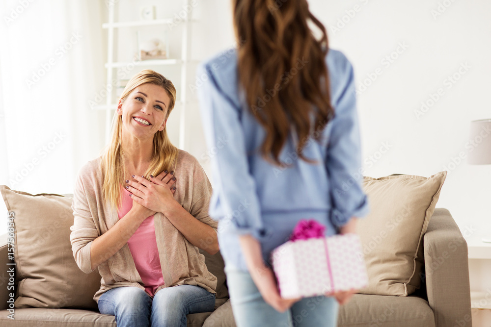 Obraz premium girl giving birthday present to mother at home