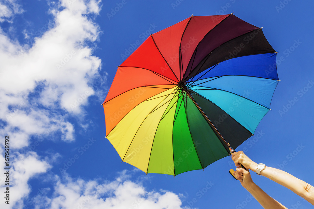 Multi-colored umbrella on the sky background