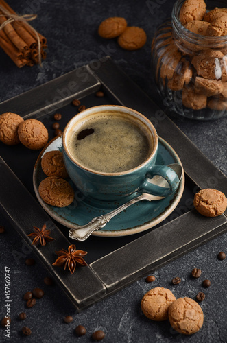 Cup of fresh coffee with Amaretti cookies on dark background, selective focus