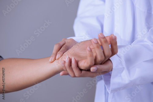 Doctor checking the pulse of a patient by hand