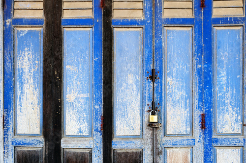 Background texture on old rustic blue wooden folding door of classic Sino-Portuguese architectural style shophouse building