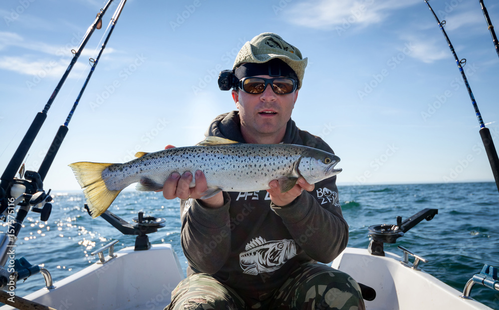 Happy angler with lake trout fishing trophy Happy angler with lake trout fishing trophy