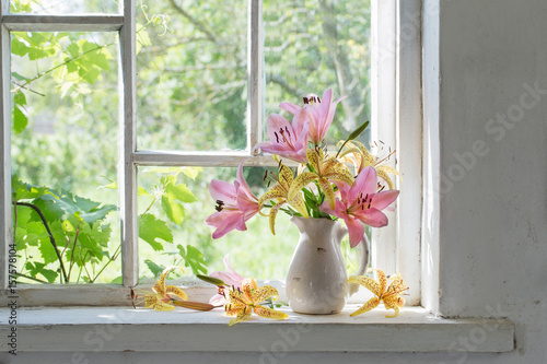 lilies bouquet on a window sill in a sunny  day