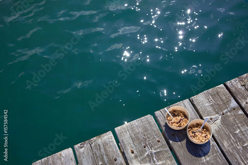 Two plates of oatmeal, stand on the pier in the sea. © felix1123