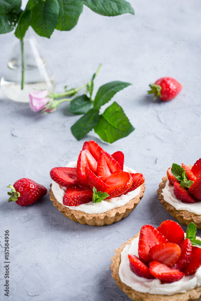 Strawberry vanilla cream cheese tarts over light gray table Strawberry vanilla cream cheese tarts over light gray table