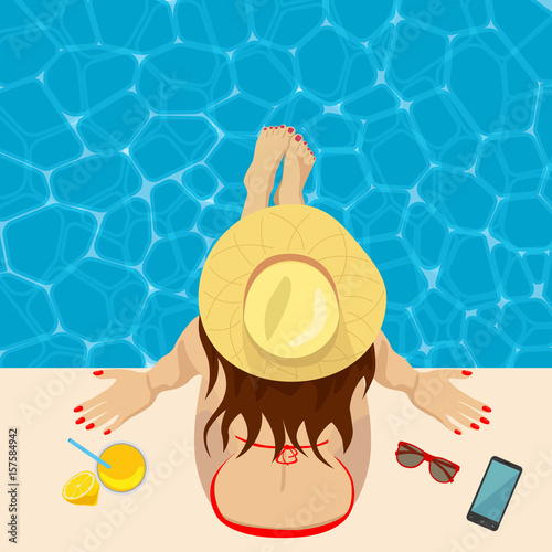 Young woman in straw hat sitting on the edge of swimming pool. Top view