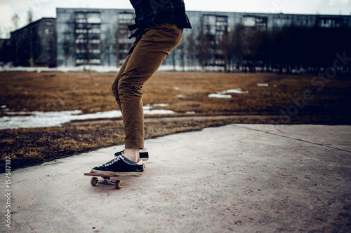 skateboarder guy prepares for a stunt on a skateboard and rides along the road. Concept forward to the goal and achieve it.